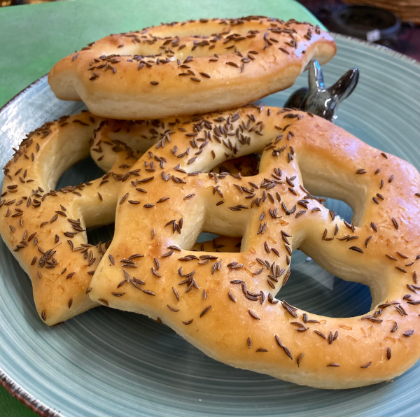 Ein Teller mit drei Faschtewäije an welchen ein kleiner Porzellanhase knabbert